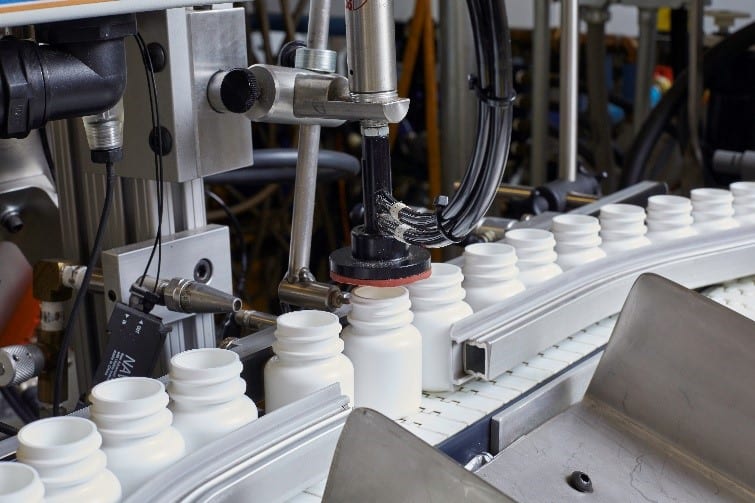 White cannabis bottles in a manufacturing line